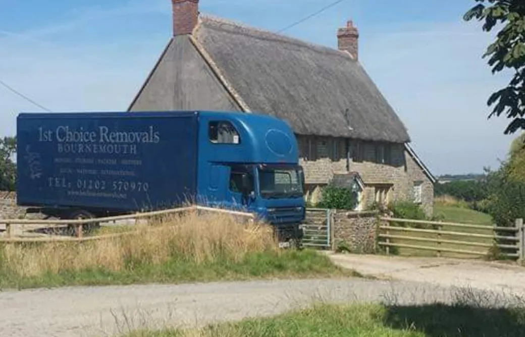 1st Choice Removals lorry outside a thatched cottage
